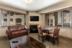 Carpeted dining room featuring a textured wall and a glass covered fireplace