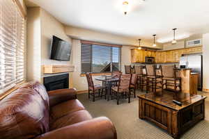 Living room with light colored carpet and a glass covered fireplace