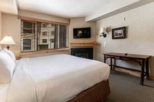 Carpeted bedroom featuring a textured wall