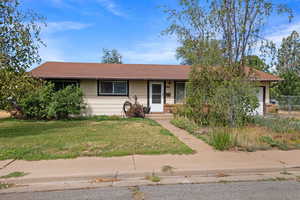Ranch-style house featuring a front lawn and a garage