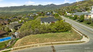 Aerial view of property and surrounding area with mountains and nearby suburban area
