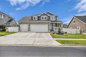 Craftsman-style house featuring covered porch, concrete driveway, stone siding, an attached garage, and stucco siding