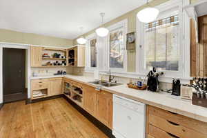 Kitchen featuring open shelves, light brown cabinets, backsplash, white dishwasher, and light wood finished floors