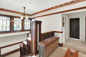 Bedroom with light carpet and a chandelier