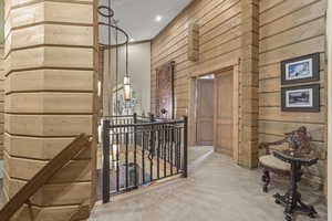 Corridor featuring an upstairs landing, wood walls, carpet floors, and recessed lighting