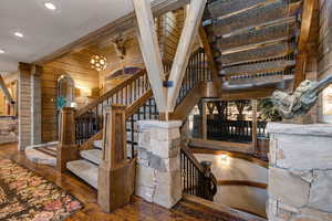 Stairs with wood walls, wood-type flooring, a chandelier, and recessed lighting