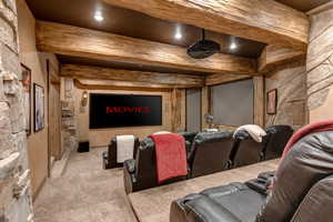 Cinema featuring carpet flooring and beamed ceiling