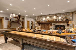Playroom with a stone fireplace, recessed lighting, and carpet