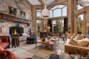 Living room with a fireplace, high vaulted ceiling, and beamed ceiling