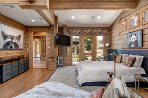 Bedroom featuring wooden walls, wood finished floors, access to outside, recessed lighting, and radiator heating unit