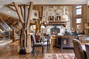 Living room featuring dark wood-style floors, a fireplace, and a high ceiling