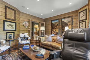Living room featuring wooden walls, recessed lighting, and wood finished floors