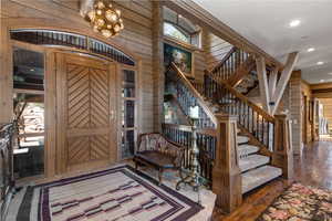 Foyer with stairs, log walls, plenty of natural light, dark wood-type flooring, and recessed lighting