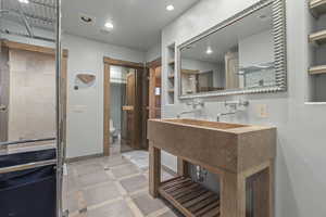 Full bathroom with inlaid floor details, recessed lighting, and vanity