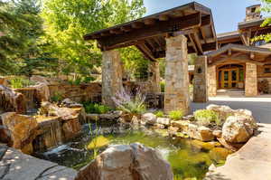 View of patio featuring a small pond and outdoor dining area