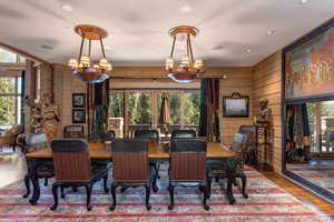 Dining space with wood finished floors, wooden walls, and recessed lighting