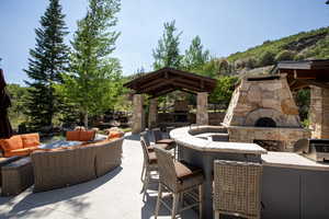 View of patio with an outdoor living space with a fireplace, grilling area, and a gazebo