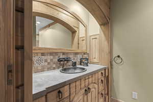 Bathroom featuring decorative backsplash and vanity