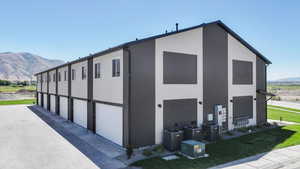 View of property exterior with a mountain view, stucco siding, and a yard