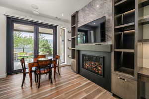 Dining area featuring a fireplace, built in shelves, wood finished floors, and recessed lighting