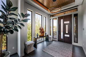 Foyer entrance featuring wooden ceiling, wood finished floors, and a tray ceiling