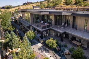 Back of house with a patio area and stone siding
