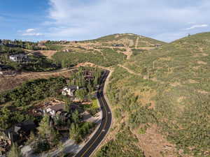 Aerial view of property and surrounding area featuring mountains and a heavily wooded area
