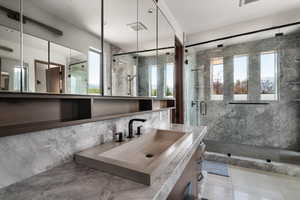 Full bath featuring a marble finish shower, healthy amount of natural light, tile walls, vanity, and tile patterned floors