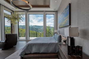 Bedroom featuring access to outside, a mountain view, wallpapered walls, wood finished floors, and recessed lighting