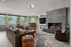 Living room with a fireplace, recessed lighting, and light tile patterned floors