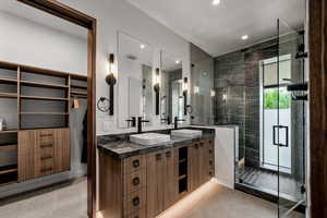 Bathroom featuring double vanity, a shower stall, and recessed lighting