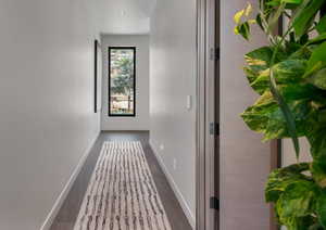 Hall with baseboards and dark wood-style flooring
