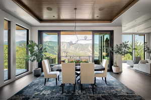 Dining space featuring a tray ceiling, wooden ceiling, and a mountain view