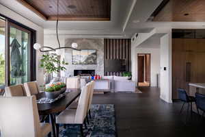 Dining space with wood ceiling, a tray ceiling, and a fireplace