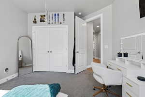 Bedroom with light carpet and a closet