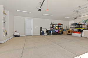Garage with baseboards and a garage door opener