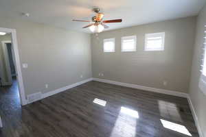Unfurnished room featuring dark wood finished floors and ceiling fan