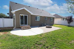 Back of property with a patio area, a shingled roof, a fenced backyard, stucco siding, and an outdoor fire pit