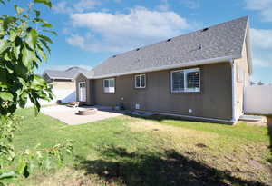 Back of house featuring a patio, roof with shingles, and an outdoor fire pit