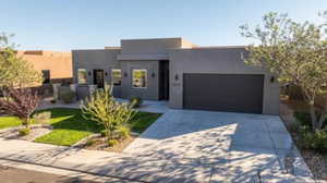 Contemporary house with an attached garage, stucco siding, and concrete driveway