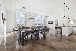 Dining space featuring finished concrete floors and a tray ceiling