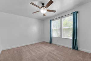 Spare room with light carpet, a textured ceiling, and ceiling fan