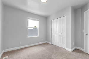 Unfurnished bedroom featuring carpet floors and a closet