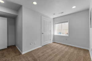 Carpeted spare room featuring recessed lighting