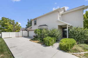 View of home's exterior featuring a garage, stucco siding, and concrete driveway
