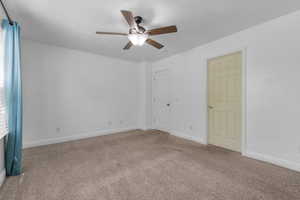 Spare room featuring carpet flooring and ceiling fan