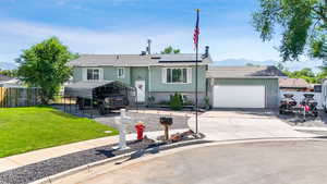Split foyer home with brick siding, roof with shingles, concrete driveway, solar panels, and an attached garage