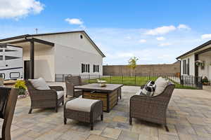 Fenced backyard with an outdoor living space and a patio area