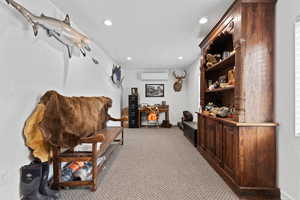 Sitting room featuring light colored carpet, recessed lighting, and a wall unit AC