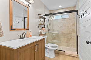 Bathroom featuring vanity, a stall shower, and light wood-style floors